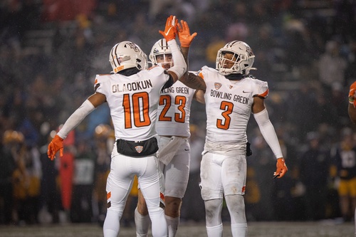 Three football payers high fiving