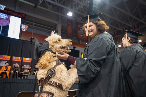 Student hugs service dog at commencement