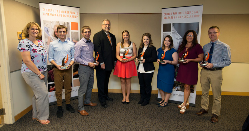 A group of students standing with two faculty members.