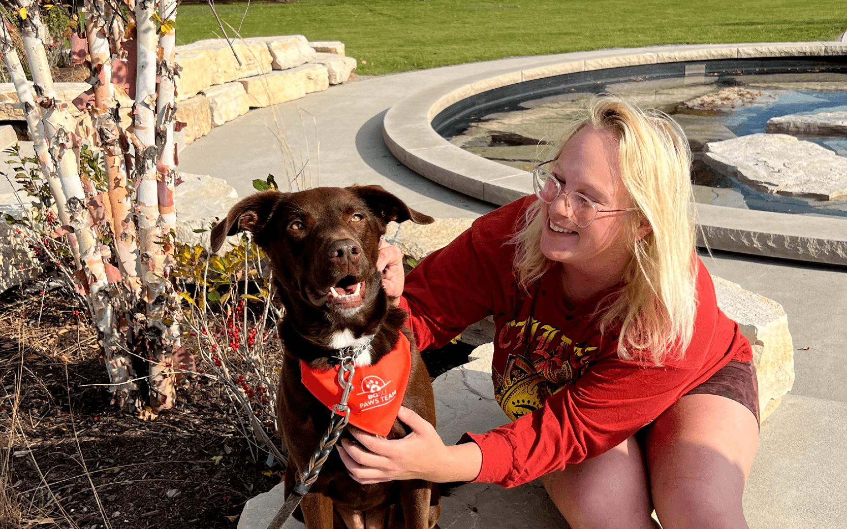 Woman petting brown therapy dog