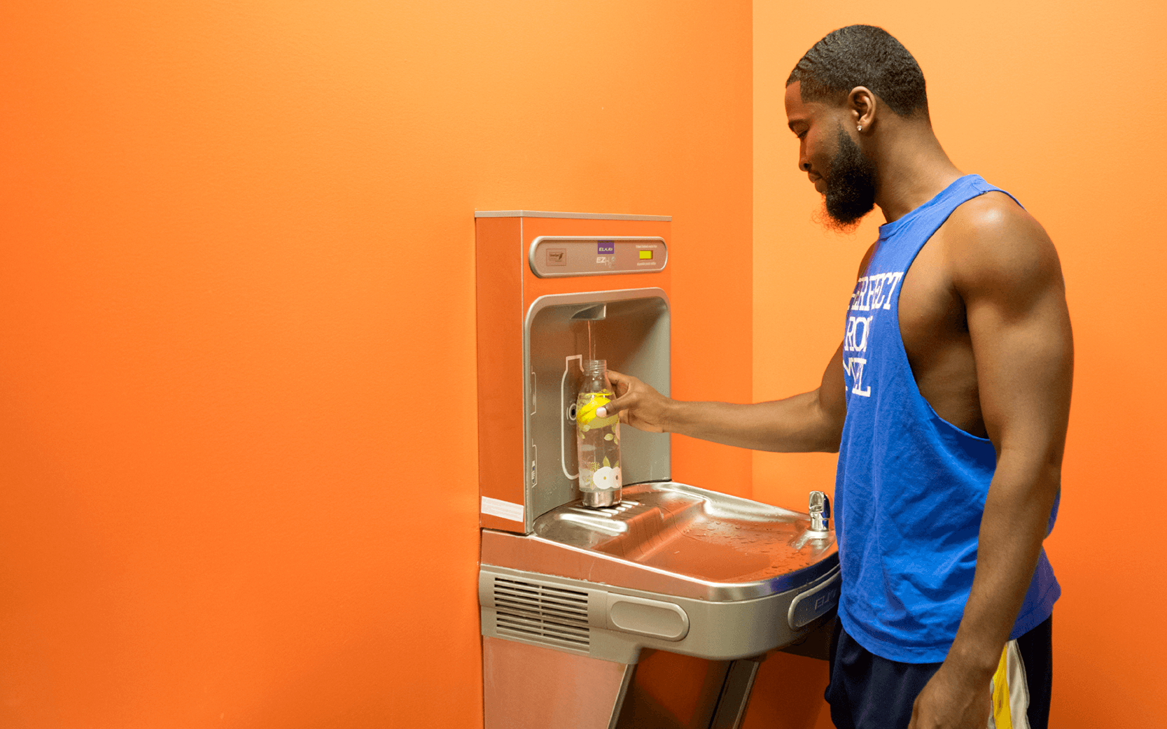 BGSU student wearing a tank top while using a water bottle refill station at the BGSU SRC