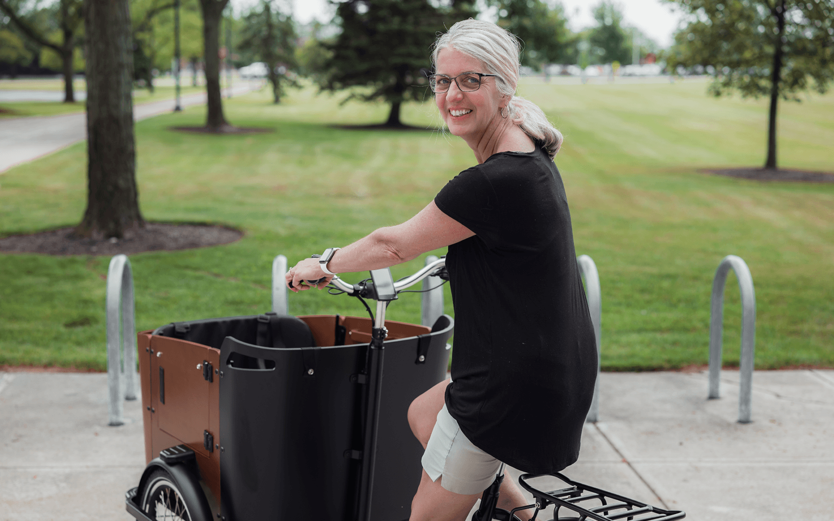 Woman in black shirt riding the BGSU cargo bike