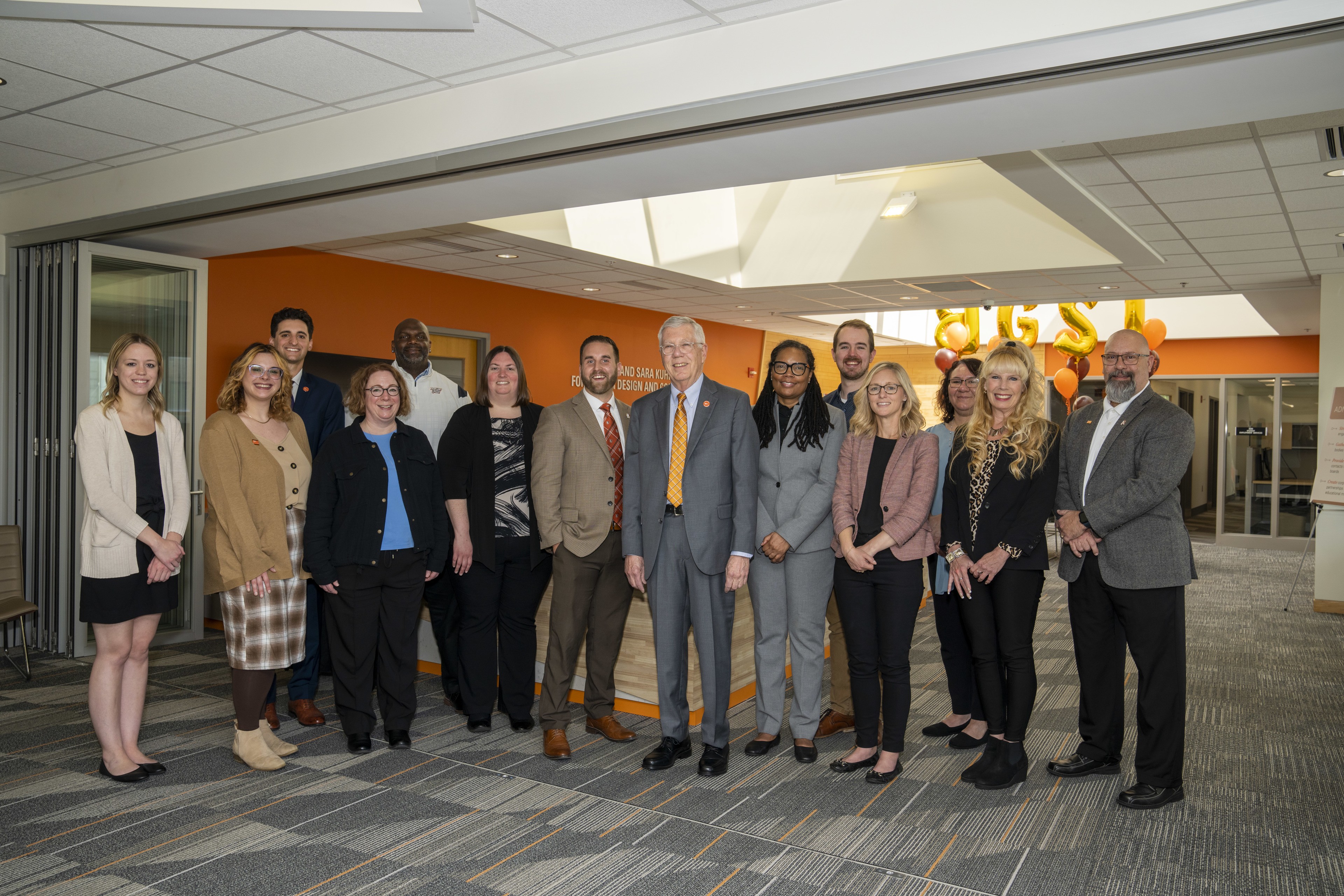  Staff of the Michael and Sara Kuhlin Hub for Career Design and Connections gather around Executive Director Steve Russell and Mike Kuhlin '68 at the May 4, 2023, reception.