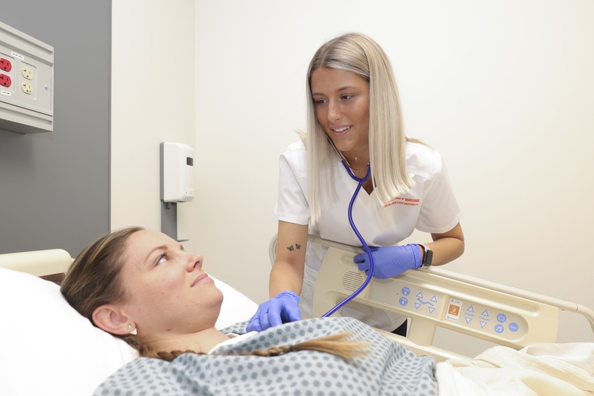 Nurse uses stethescope on a patient