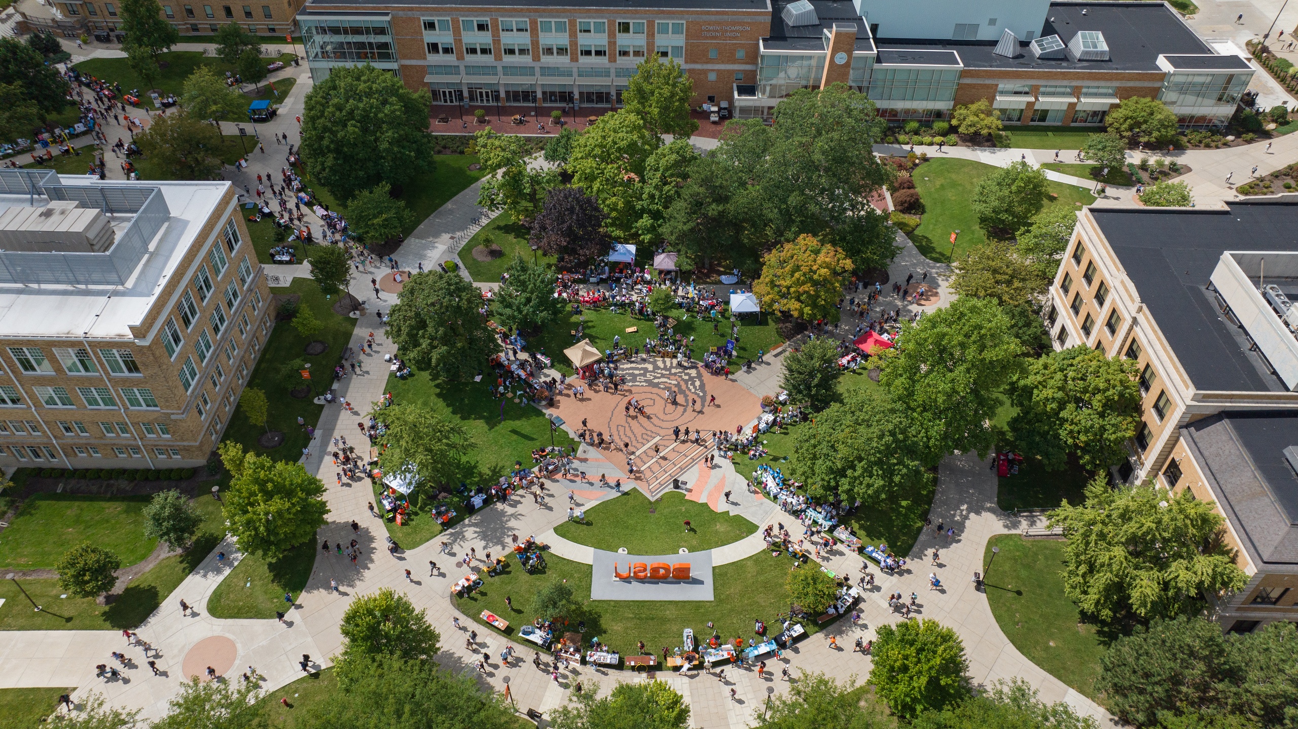 An aerial view of the Bowen-Thompson Student Union Oval showing hundreds of students visiting exhibitor tables set up around the oval.